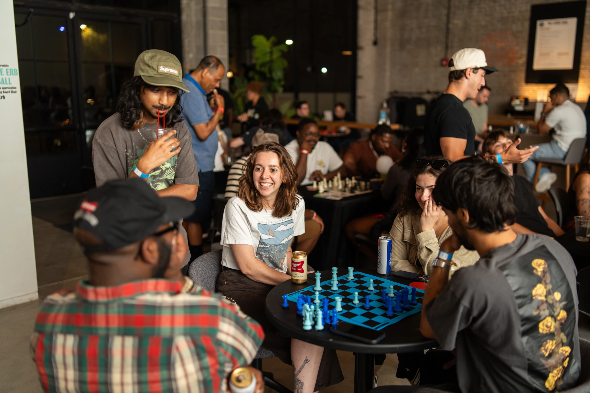A full house on chess night — drinks, boards, and exposed brick